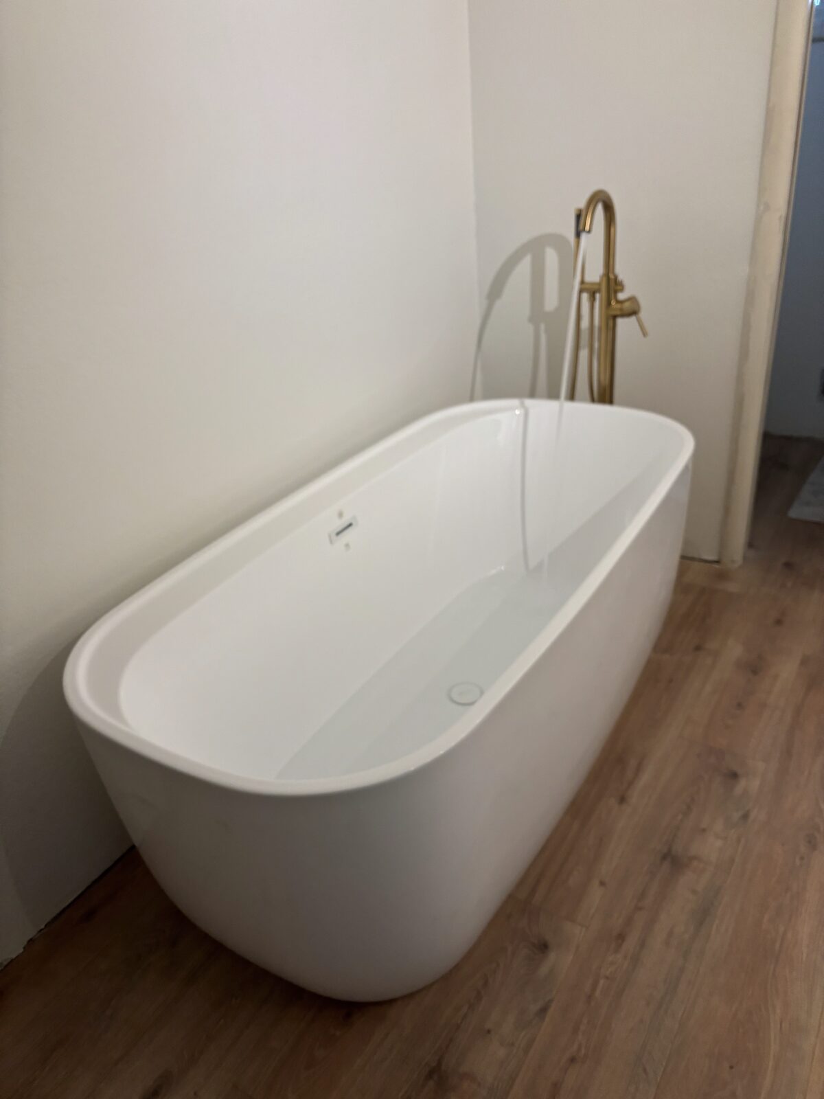 Freestanding tub with floor-mounted brass filler
